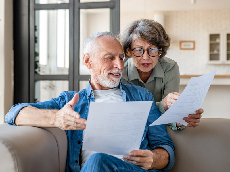 couple smiling and looking at paperwork