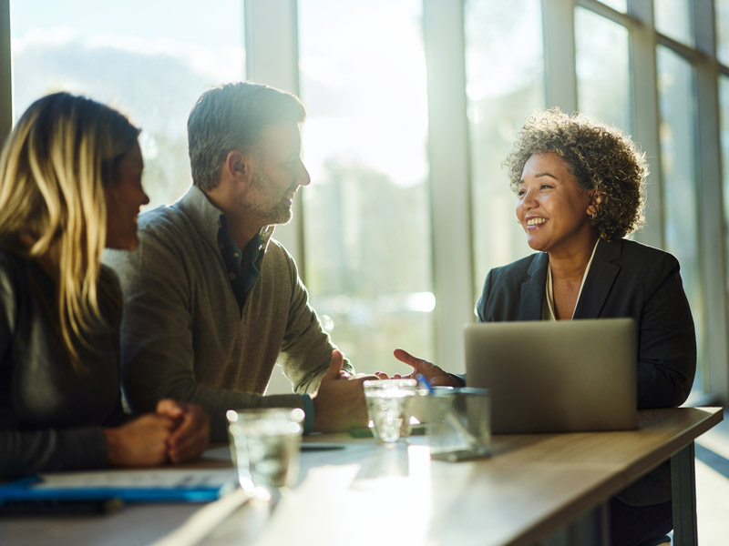 couple smiling and talking to probate specialist in office